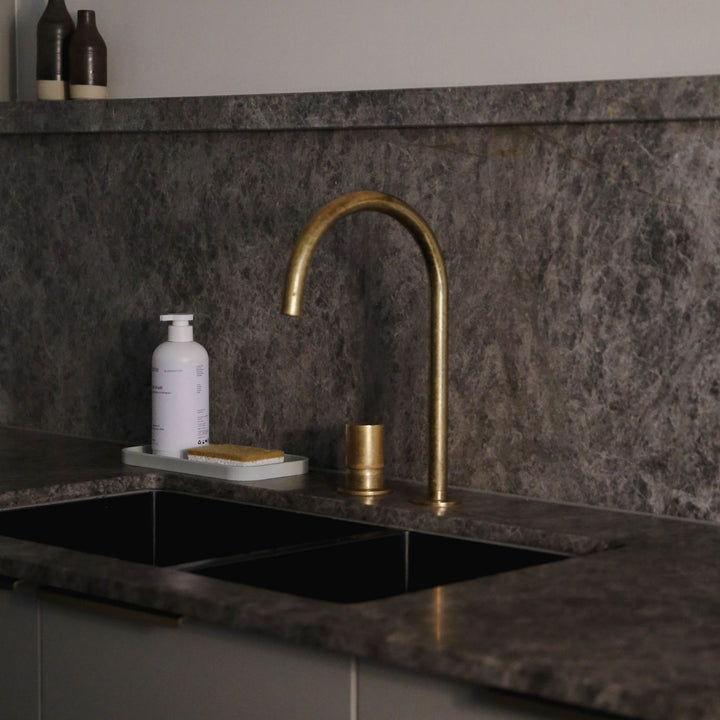 Natural lighting, perspective view of a sponge placed on a kitchen sink.