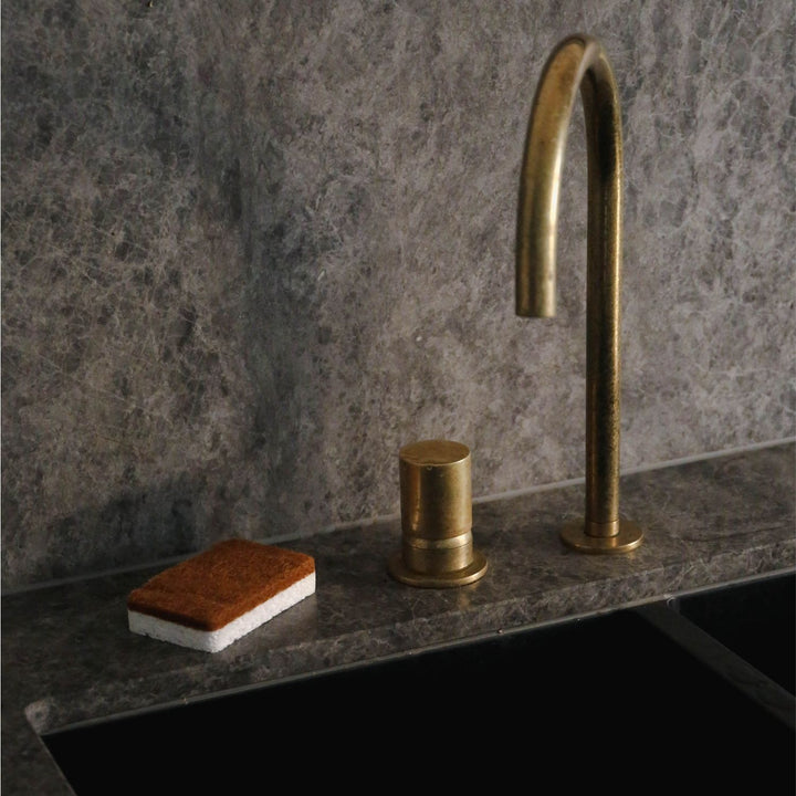 Natural lighting, perspective view of a sponge placed on a kitchen sink.