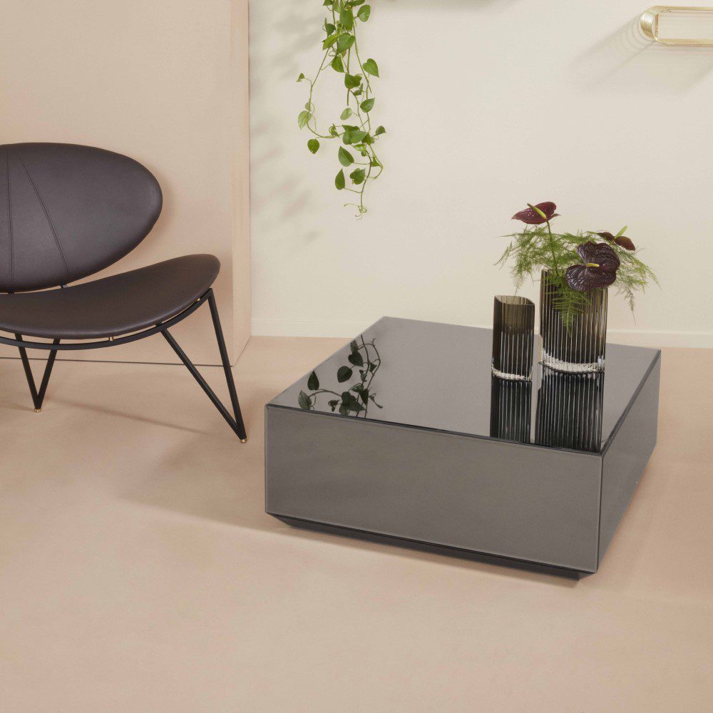 Natural light living room with a cube-shaped mirror table placed next to a chair