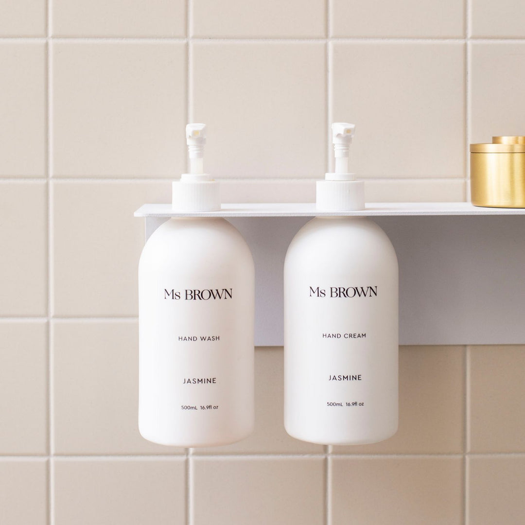 Close up of the White DESIGNSTUFF Shelf w/ Dual Soap Dispenser Holder 40cm in a bathroom with white tiles