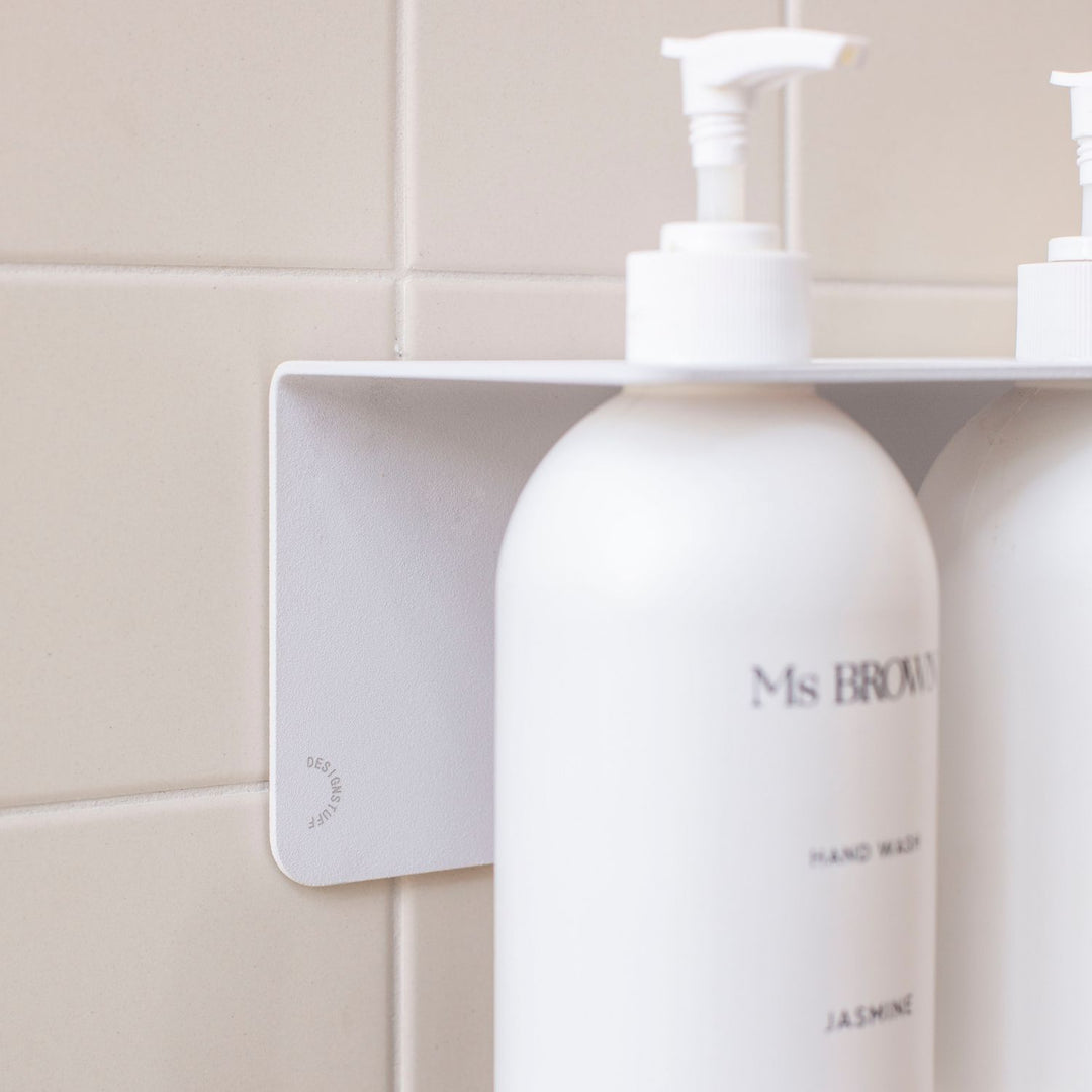 Close up of the White DESIGNSTUFF Shelf w/ Dual Soap Dispenser Holder 40cm in a bathroom with white tiles