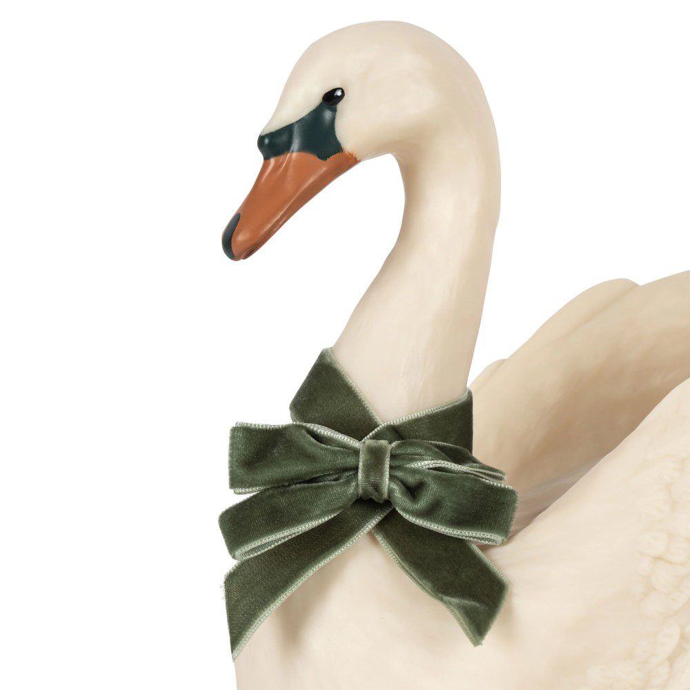 Studio lighting, close up view of a decorative swan-shaped lamp's neck with a bow.