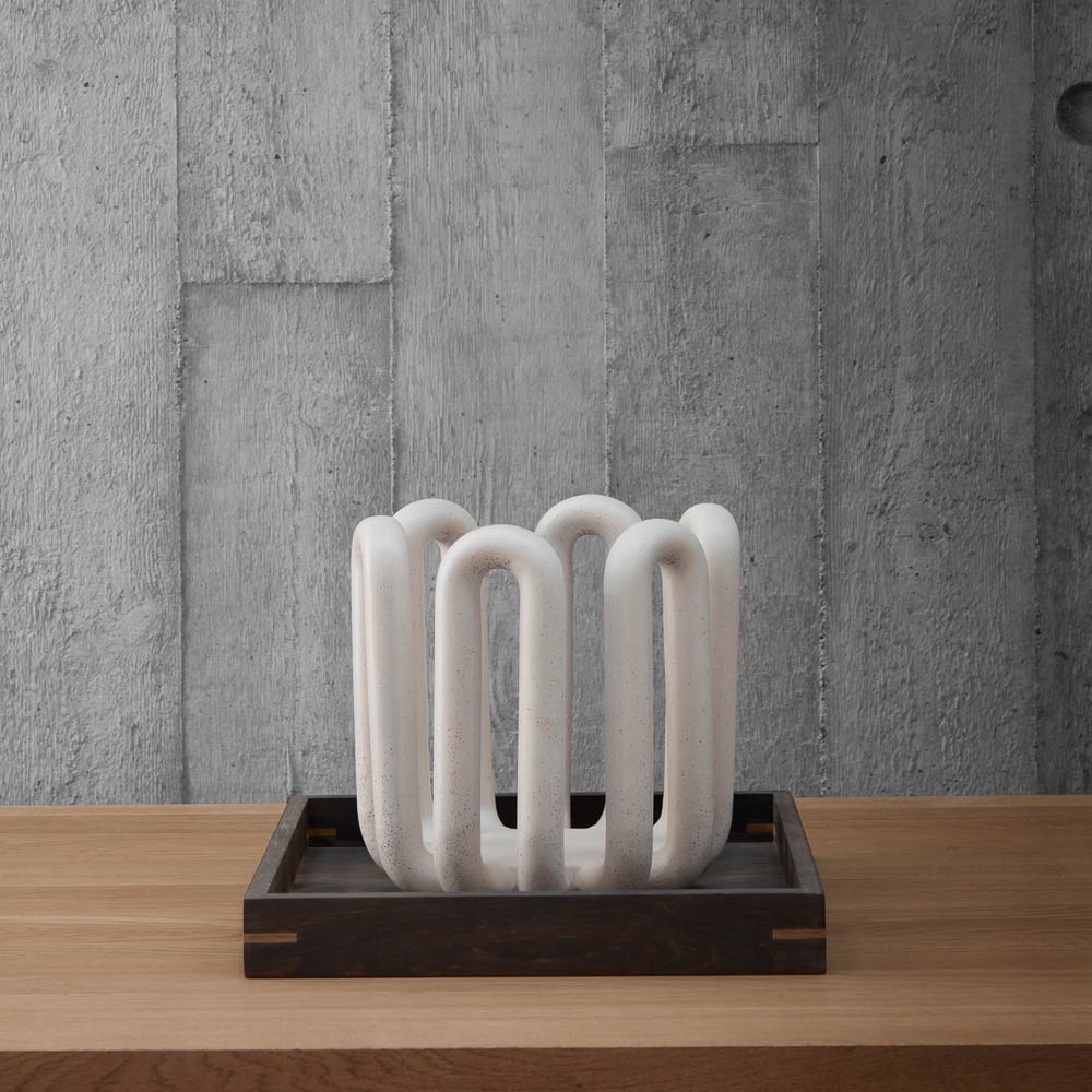 A vase on the Japanese wooden oiled oak tray with a concerete wall in the background