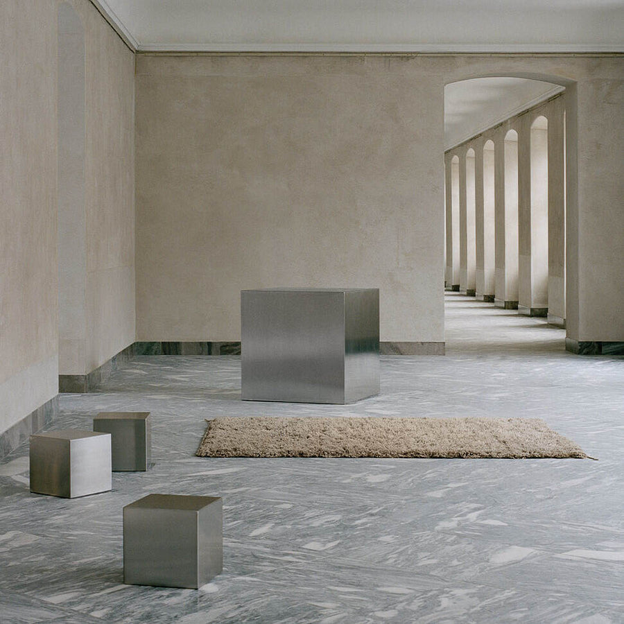 A hand-woven Luminary Sun wool rug by Linie Design with cubicals.