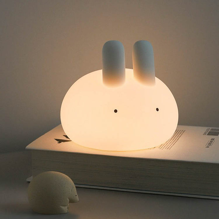 Bunny night lamp in white on top of the book